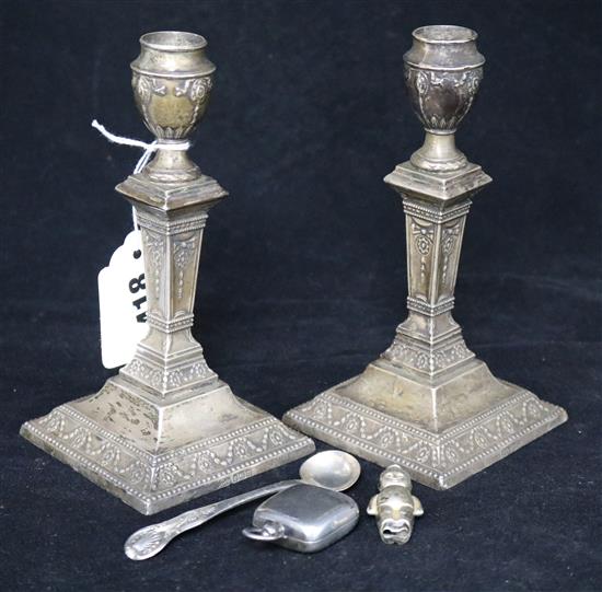 A pair of Edwardian silver candlesticks, sovereign case, rattle and condiment ladle.